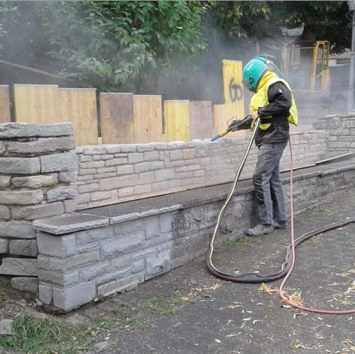 Sandstrahlen einer Mauer
